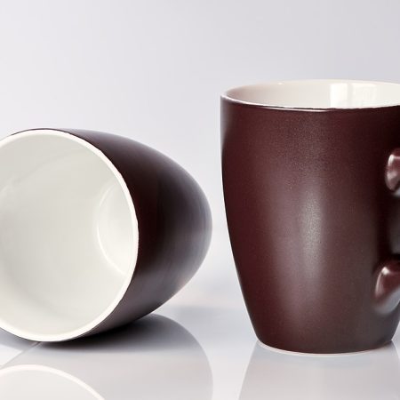 Two brown mugs on a white surface.